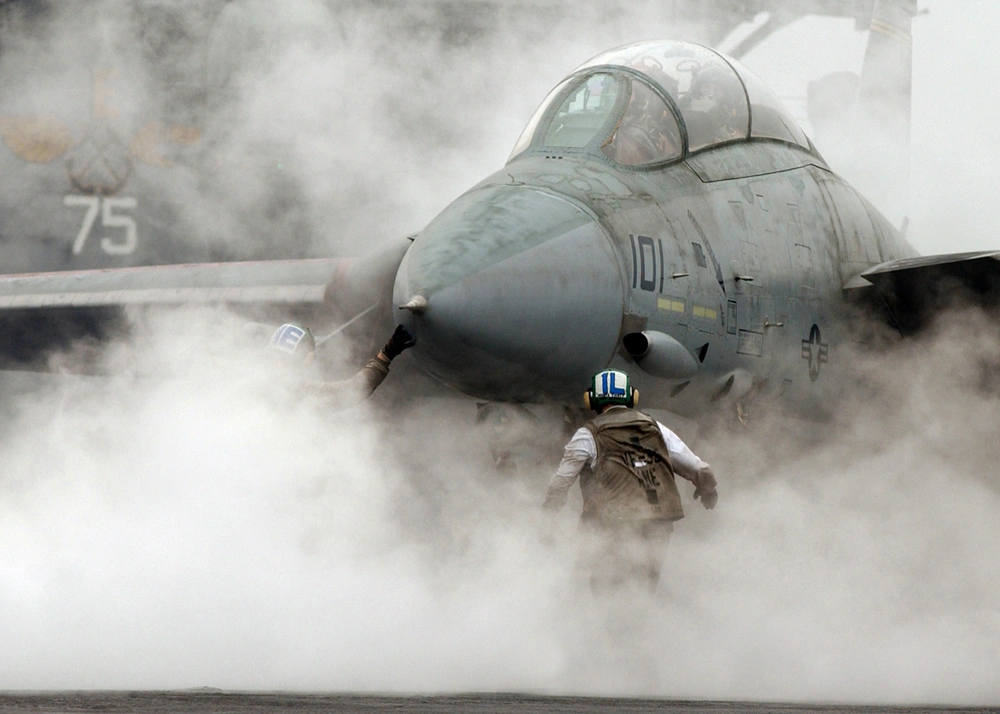 An F-14 Tomcat on USS Harry S. Truman surrounded by steam at a catapult before launch in 2005.